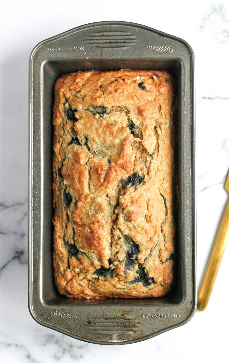 Healthy Banana Bread with White Beans in a loaf pan after baking with a gold knife