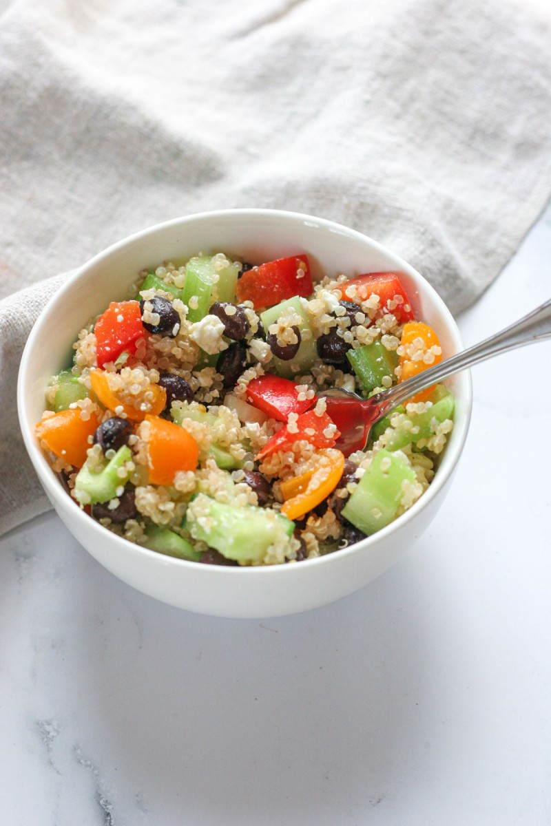 The close up of this Easy Quinoa Salad with Feta in a small white bowl with a fork in the salad