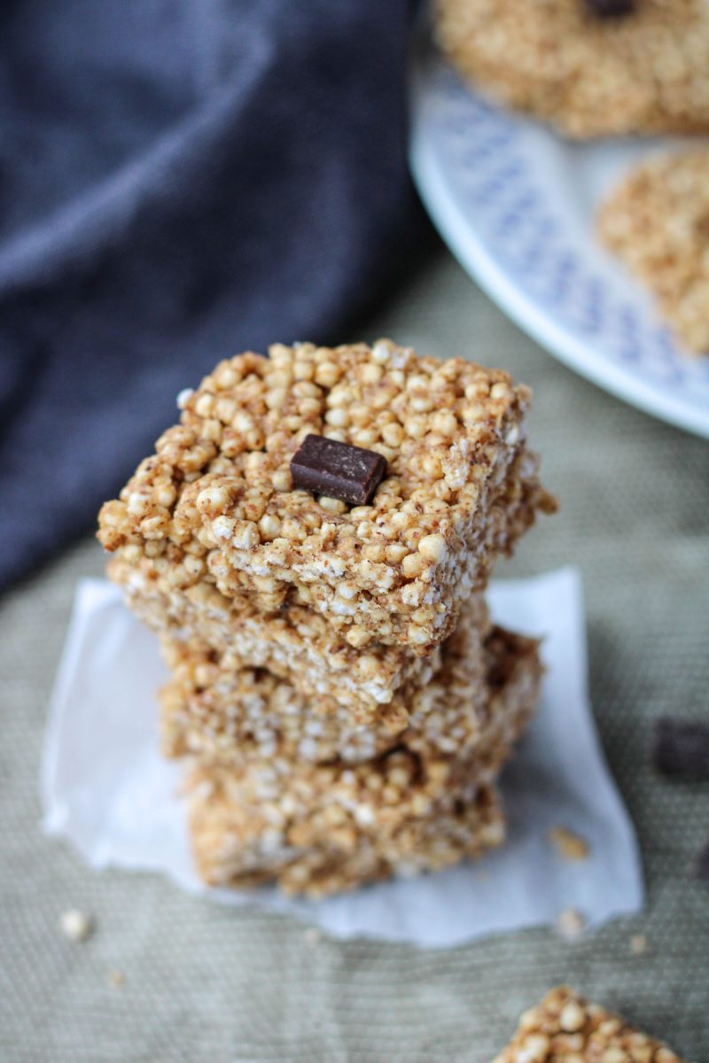 A stack of puffed quinoa squares on parchment paper.