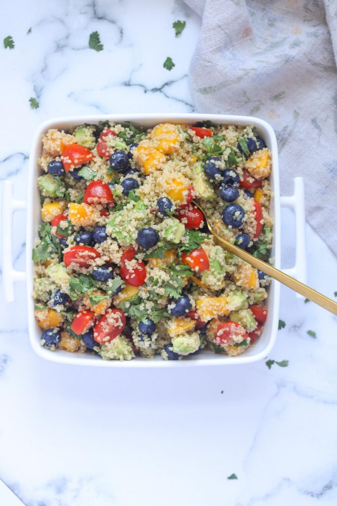 A white and square serving dish filled with Summer Quinoa Salad with Mango and Blueberries