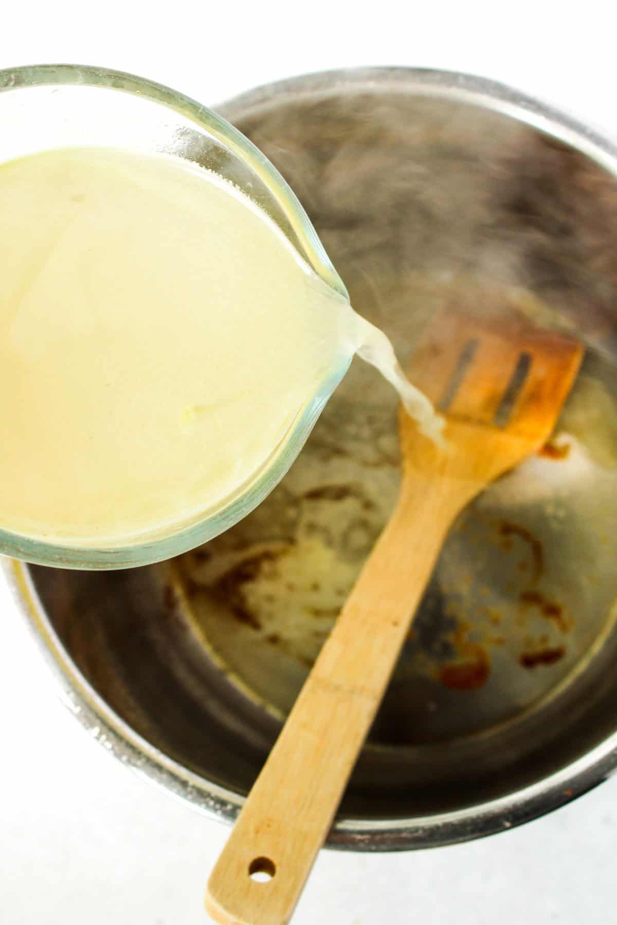 Chicken stock being added to an Instant Pot.