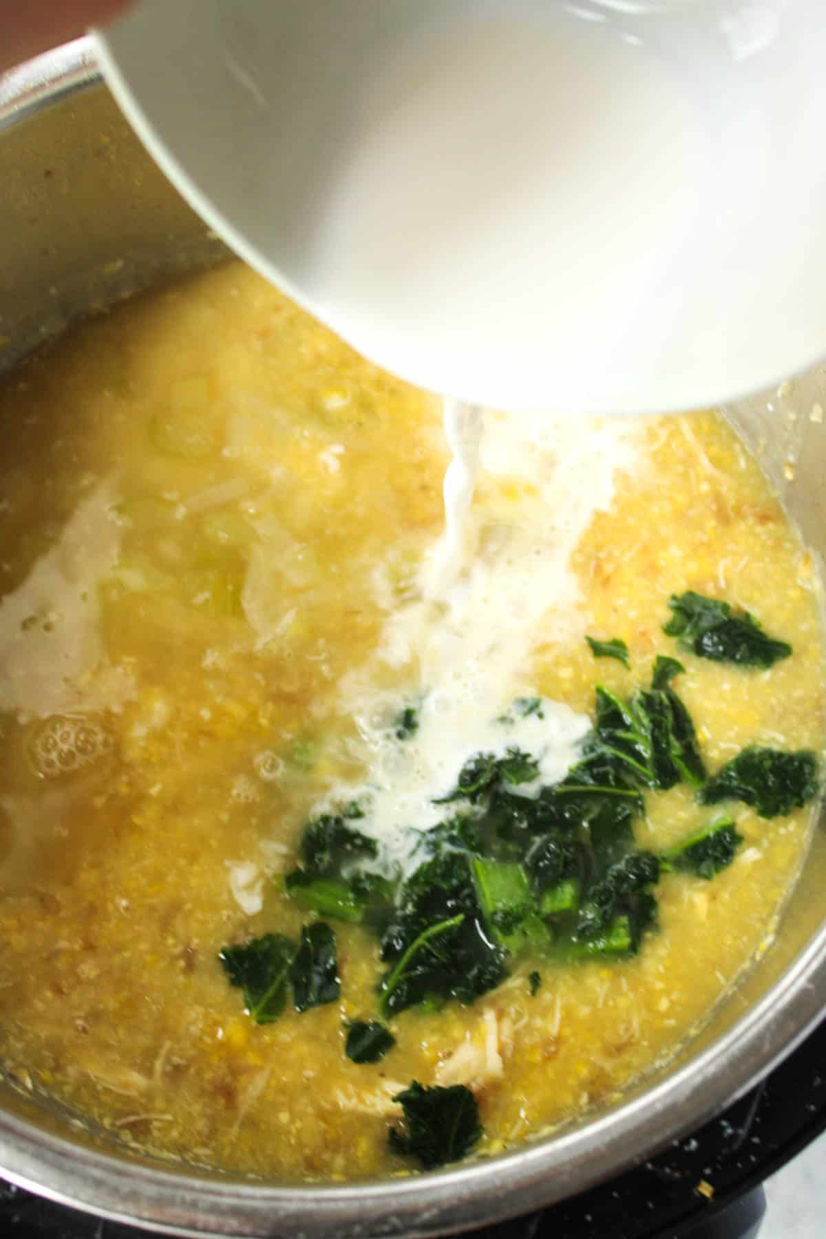 Adding cream to the corn soup.
