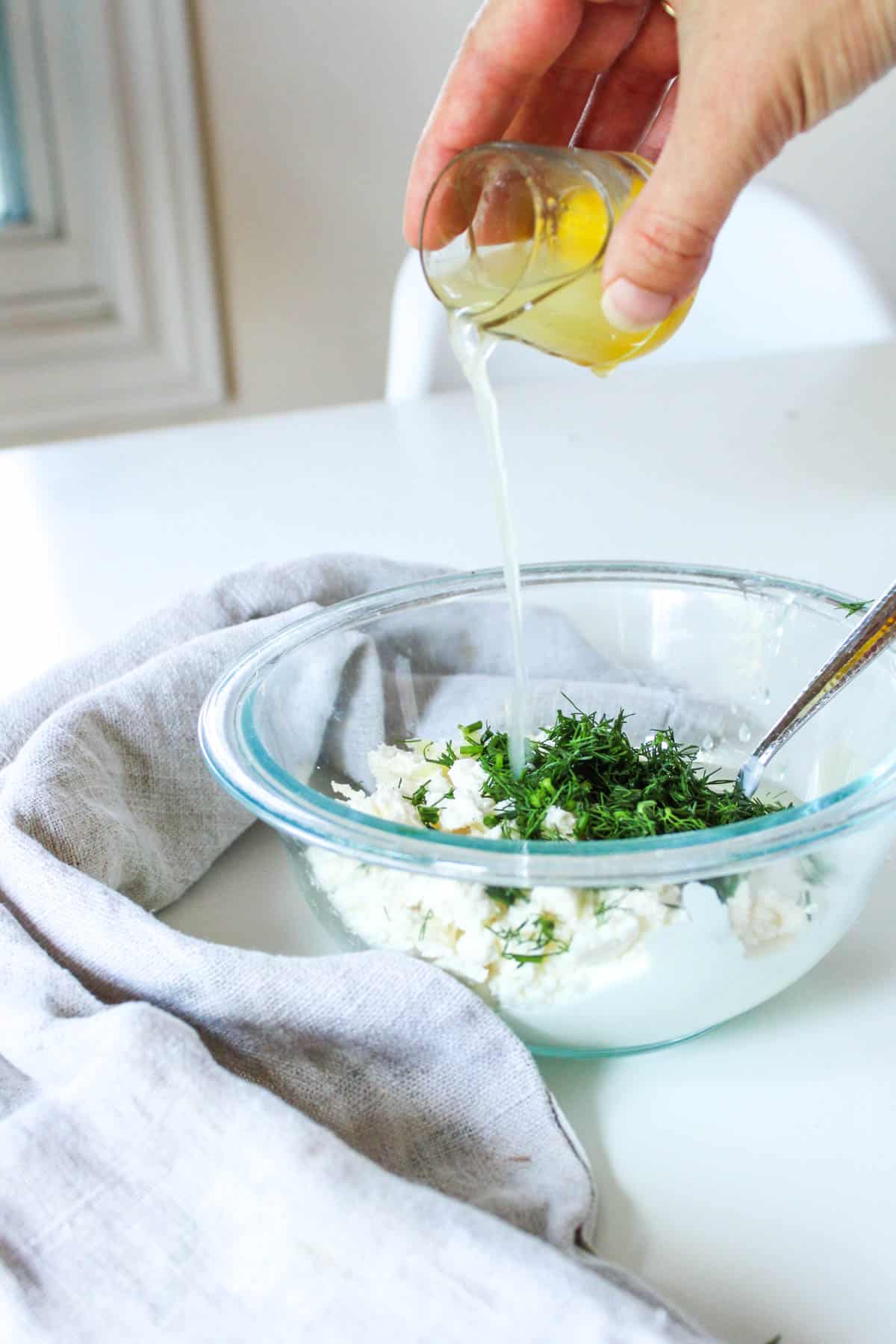Adding lemon juice to the Greek yogurt dip.