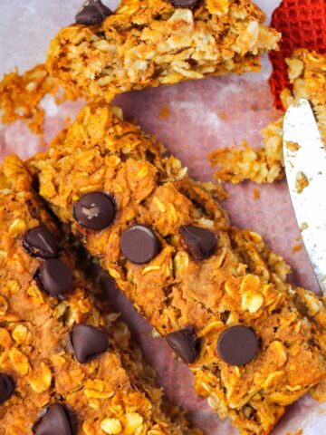 Slices of pumpkin Baked Oats with chocolate chips with a knife.