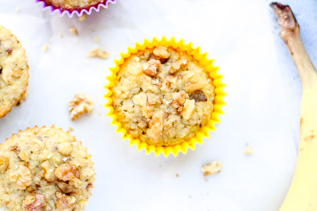 A banana oat muffin with walnuts on top.