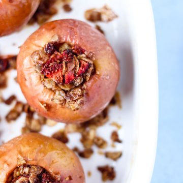 Baked apples with oats and strawberries in a white baking dish