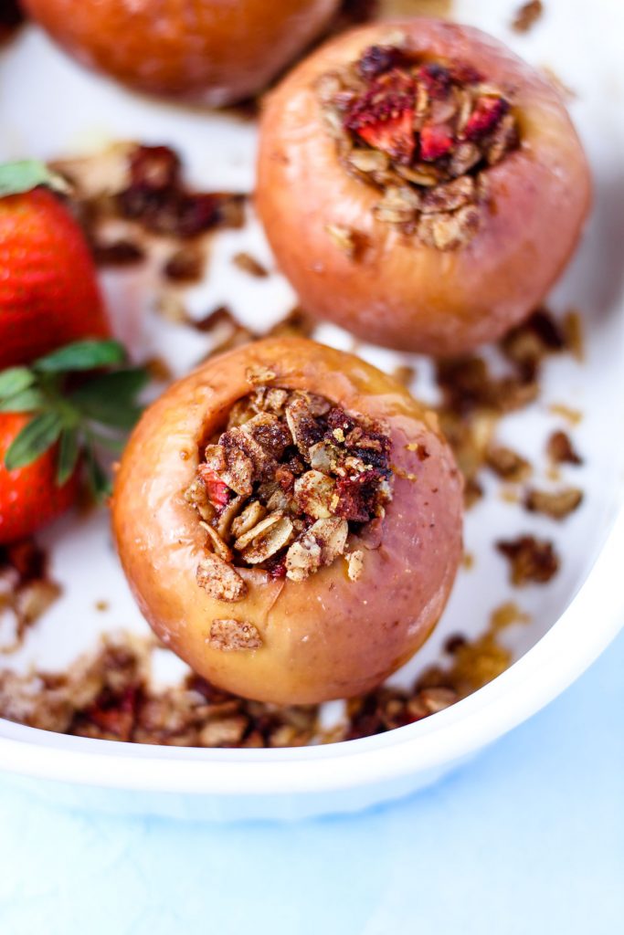 Baked apples with oats and strawberries in a white baking dish