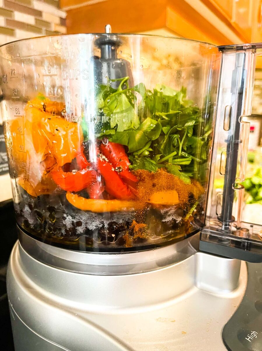 Ingredients for black bean dip with roasted red peppers in a food processor.