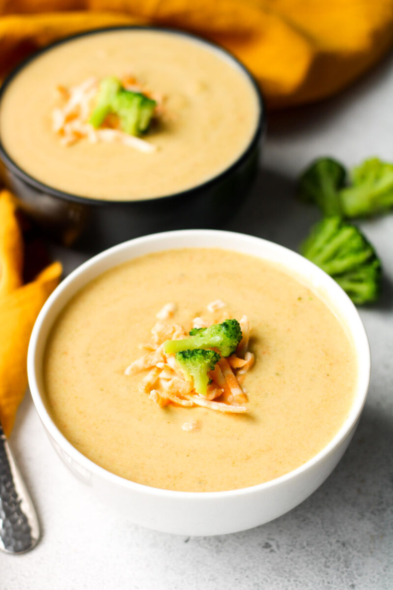 Two bowls of broccoli cheese soup.