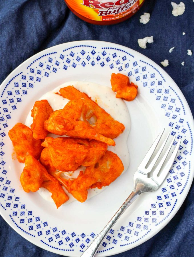 Buffalo Cauliflower Wings on a white and blue plate and a silver fork beside