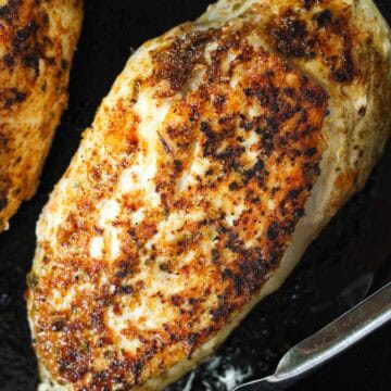 A cooked chicken breast in a cast Iron Skillet.