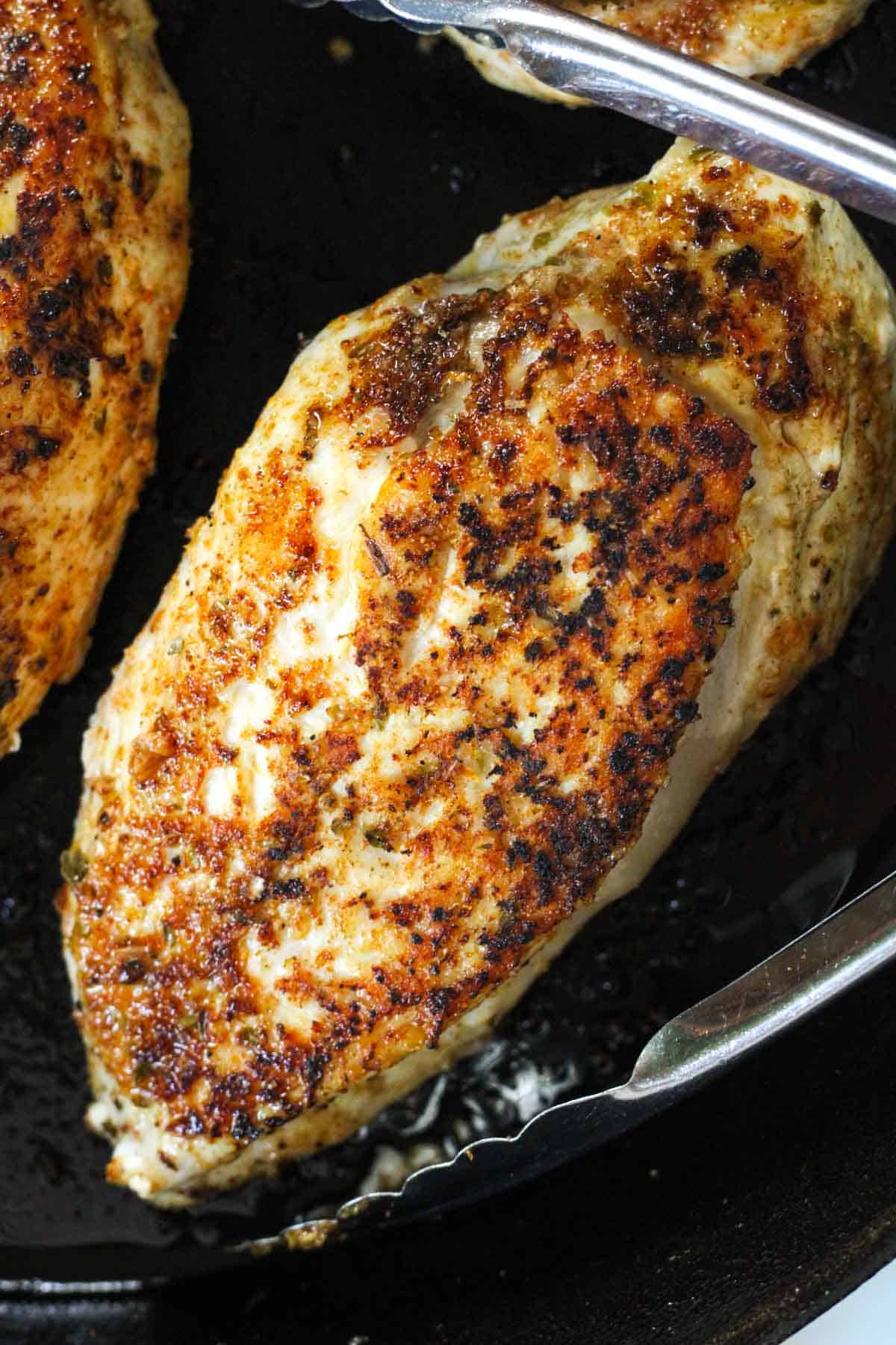 A cooked chicken breast in a cast Iron Skillet.
