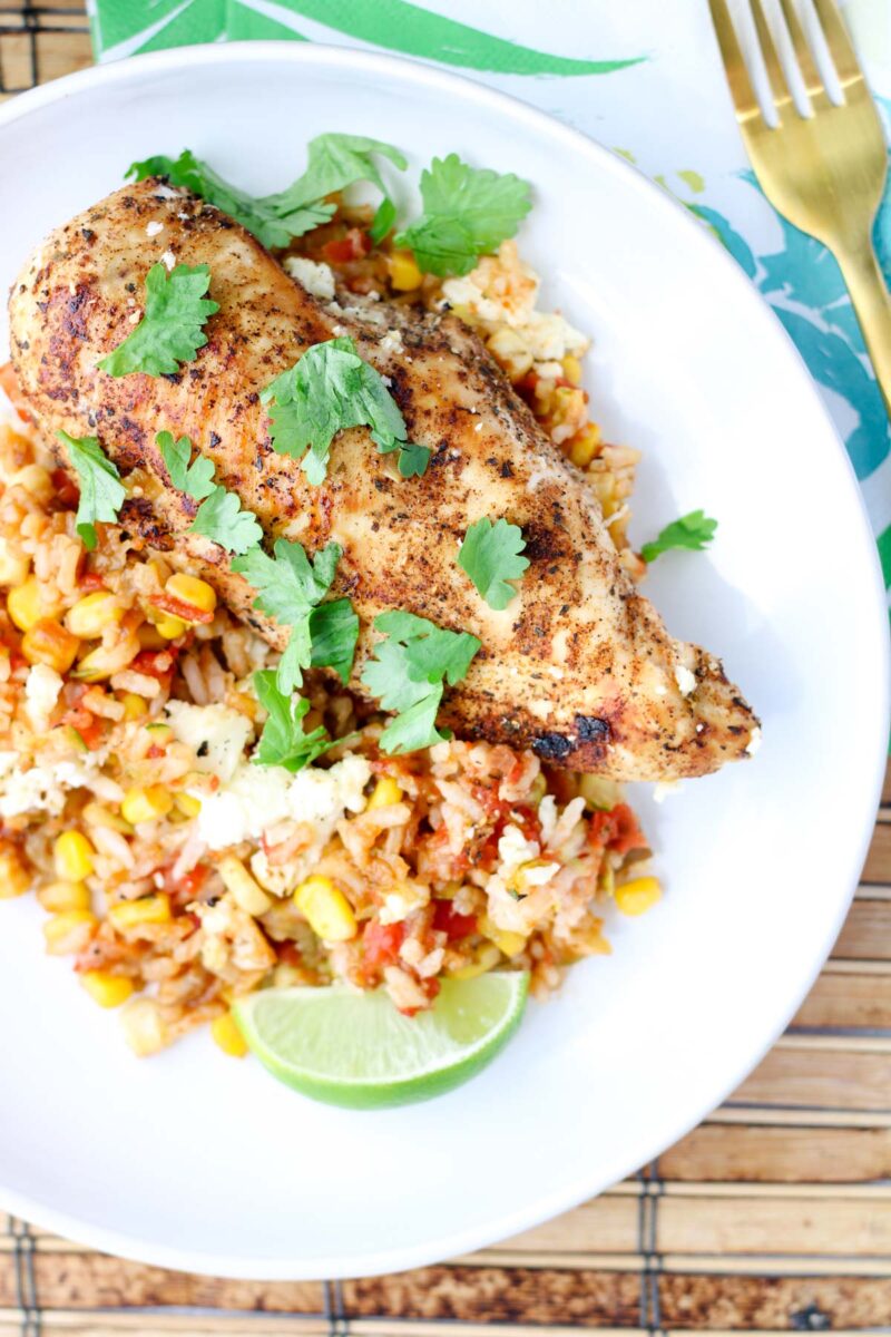 A white plate filled with chicken and rice.