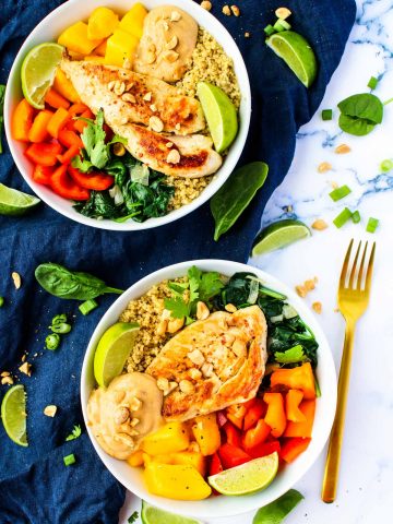 Chicken and Mango Quinoa bowls on a white countertop and gold fork