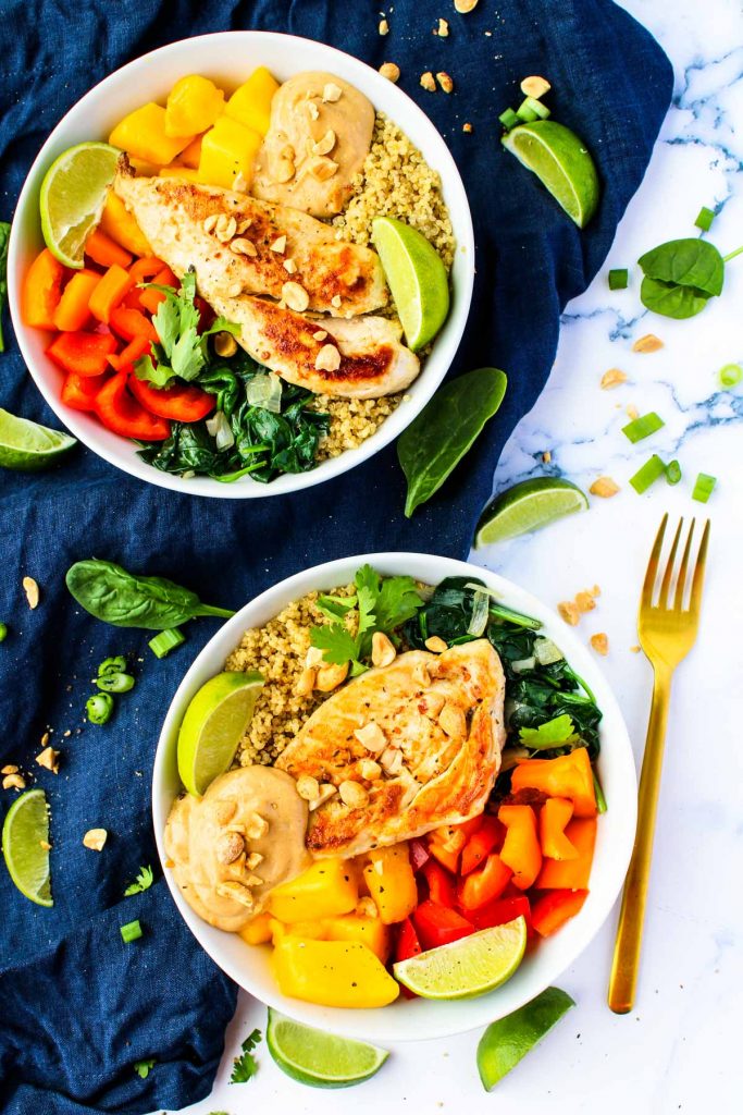 Chicken and Mango Quinoa bowls on a white countertop and gold fork
