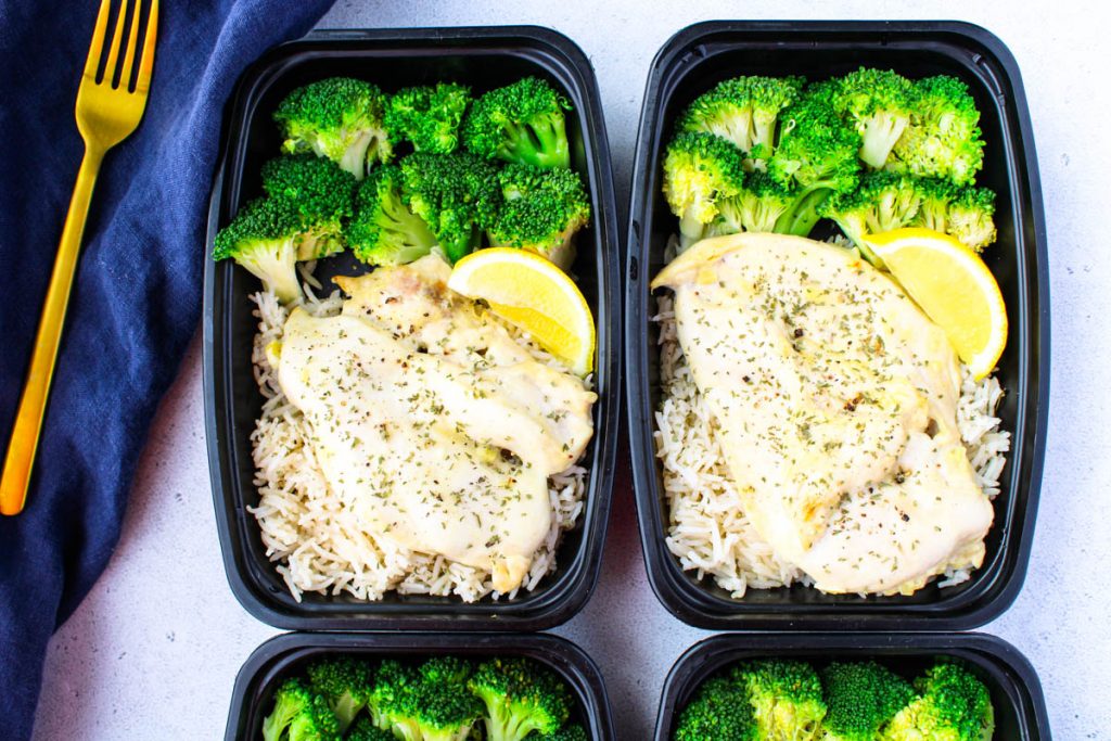 Two containers of chicken breast meal prep recipe with broccoli and rice.