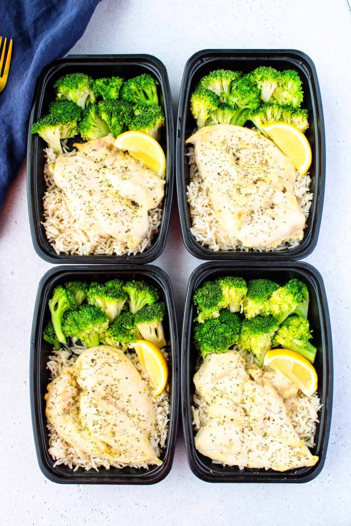Four meal prep containers with chicken, rice and broccoli meal prep.
