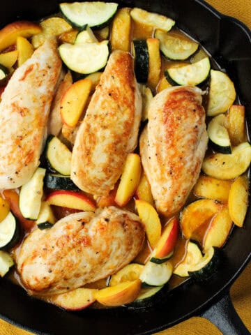 Chicken with Zucchini and Peaches in a cast iron pan.