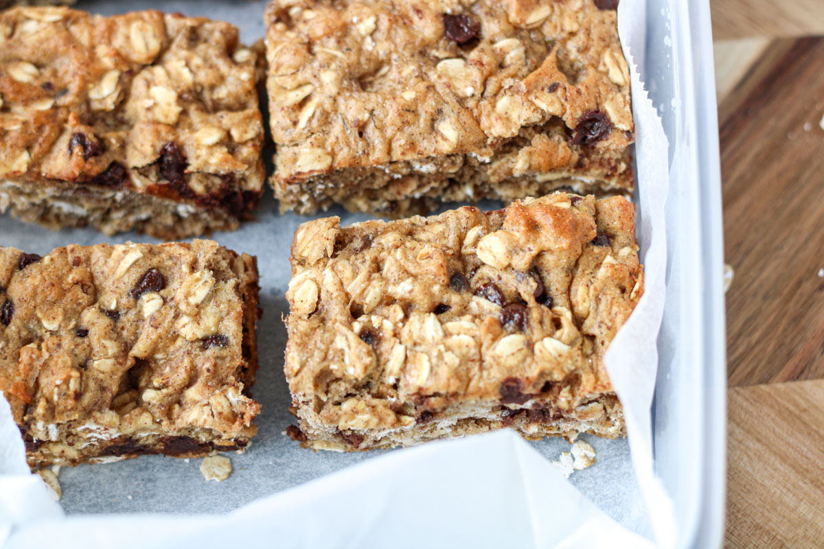 Close-up of Gluten-Free Oatmeal Breakfast Bars with Chocolate with parchment paper.