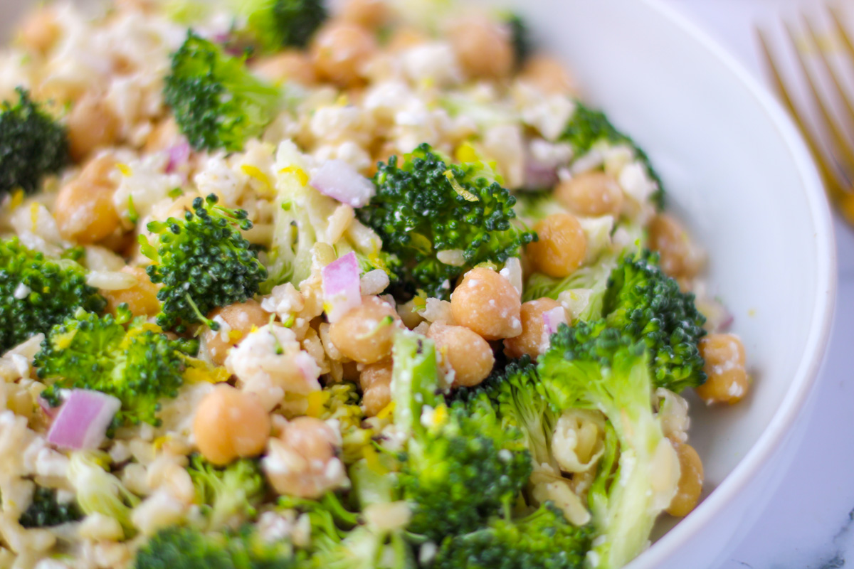 Close up of a white dish filled with Brown Rice, Broccoli and Feta Salad