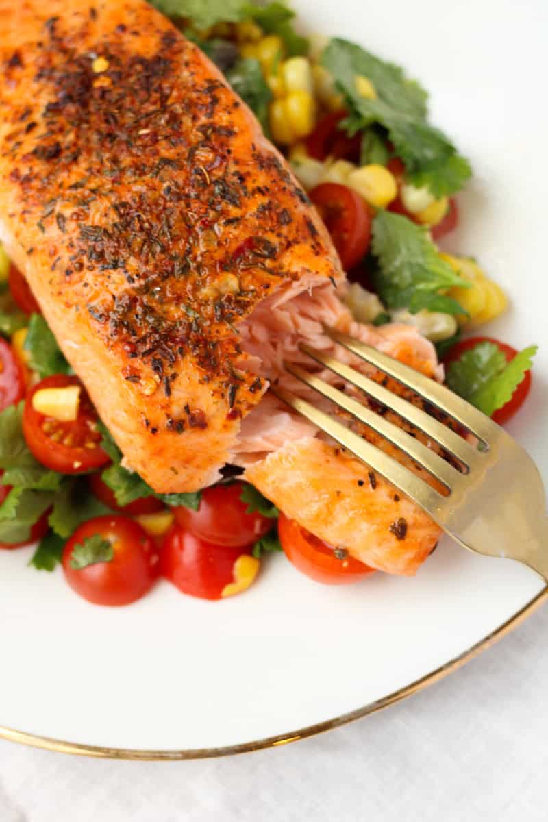 Cajun Salmon with Simple Corn Salsa on a white plate with a gold fork.