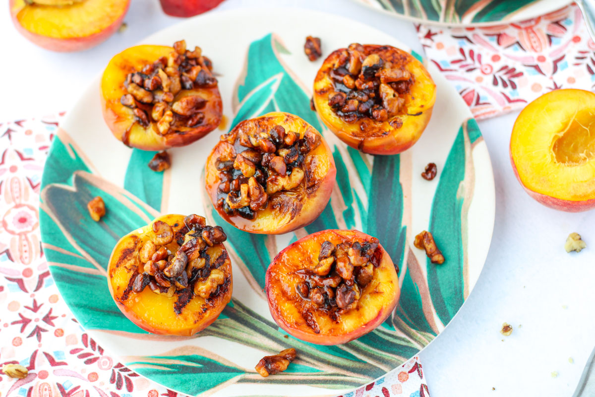 Easy Gluten Free Grilled Peaches with Walnuts on a plate with leaves