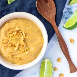 Easy Peanut Sauce with lime with a brown spoon beside
