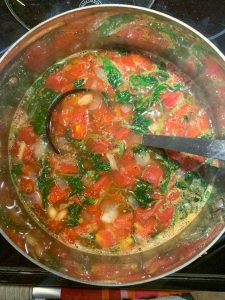 large soup pot with spinach and tomato soup with a ladle
