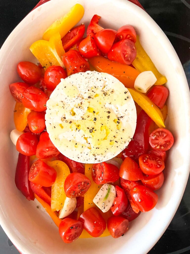 Feta and Cherry Tomatoes with olive oil on top in a baking dish.