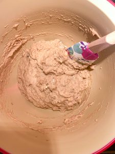 A mixing bowl with the wet and dry ingredients combined for Gluten-Free Oatmeal Breakfast Bars with Chocolate