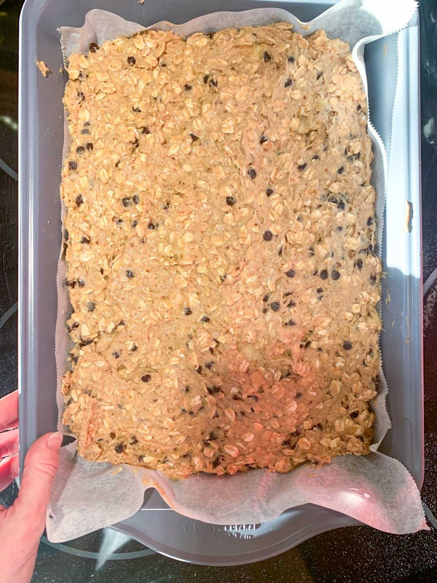 A large baking pan filled with Gluten-Free Oatmeal Breakfast Bars with Chocolate ready for oven.