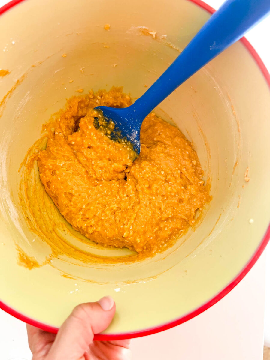 Pumpkin cookie mixture in a mixing bowl.