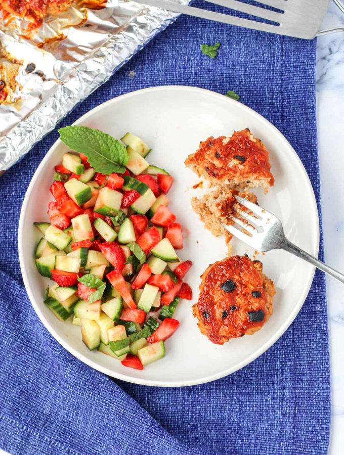 Gluten-Free Turkey Burgers on a white plate with strawberry cucumber salad