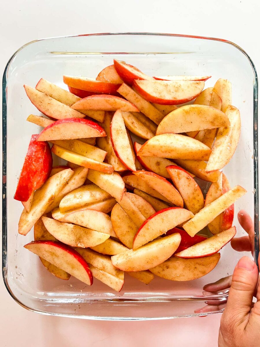 Sliced apples in a glass baking dish.
