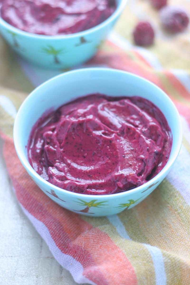 Healthy 5 Ingredient Berry Frozen Yogurt in a small blue bowl on a colourful napkin