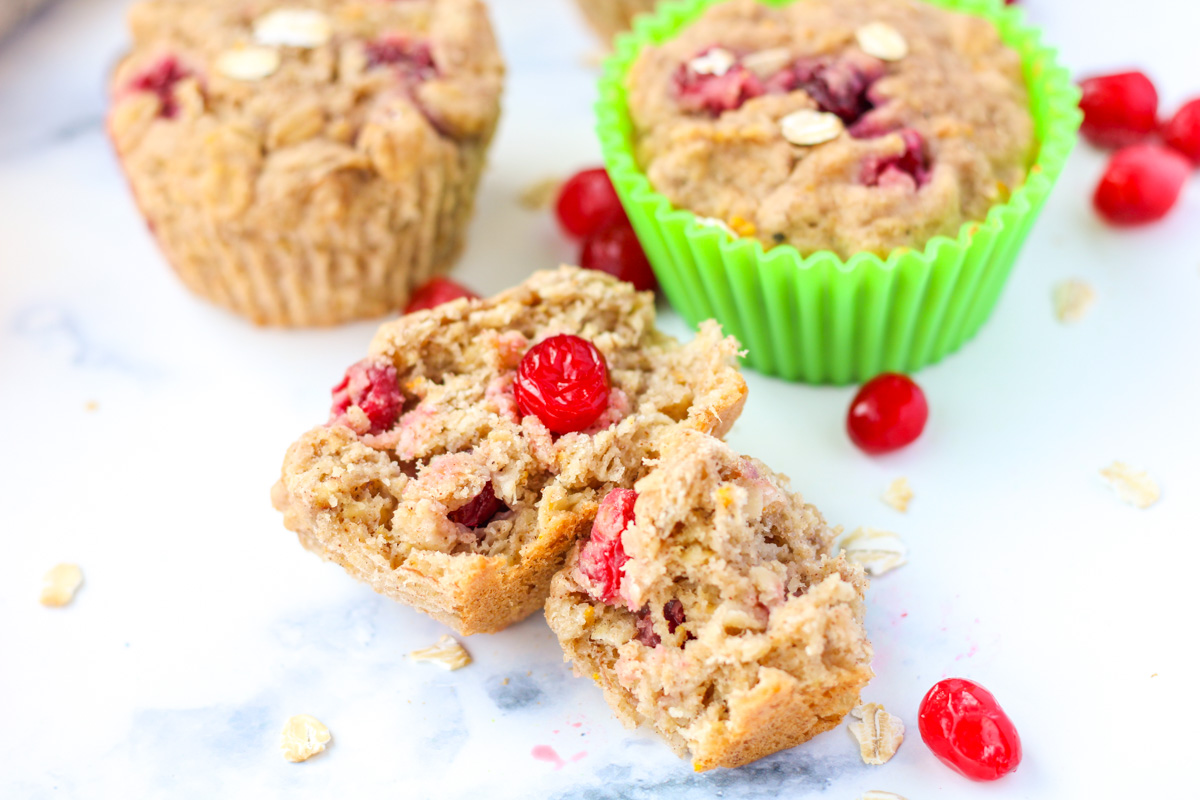a cranberry oatmeal muffin cut in 2 on a white countertop