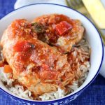 Instant Pot Sweet and Spicy Chicken Thighs in a blue and white bowl on a blue placement with gold cutlery beside