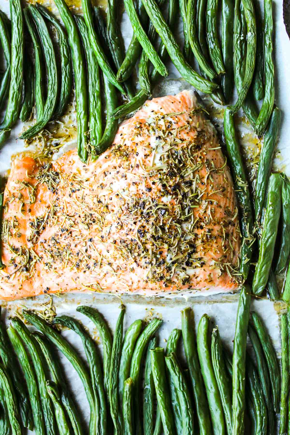 Salmon on a baking tray with green beans.