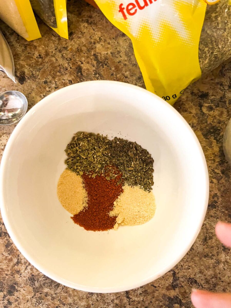 Small bowl of dried herbs and spices for chicken.