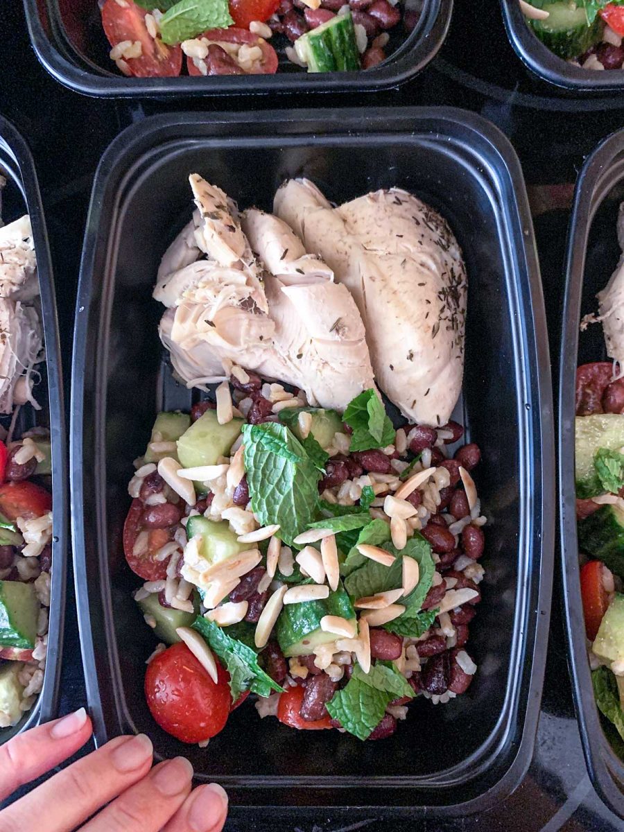 Black bean and brown rice salad with chicken breast in a meal prep container.