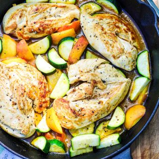 Overheat shot of chicken zucchini and peaches in a castiron pan