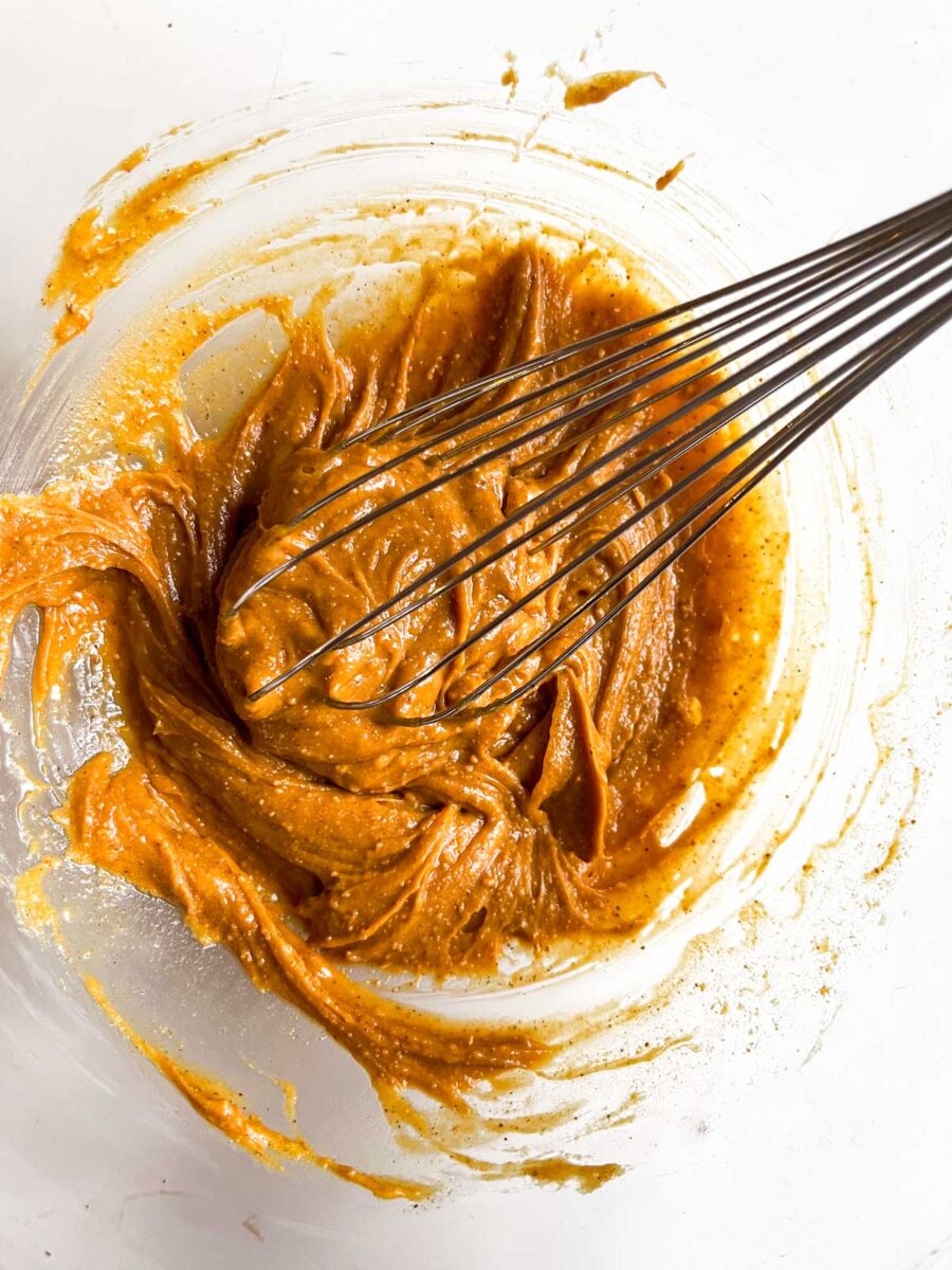 Peanut butter with a whisk in a glass bowl