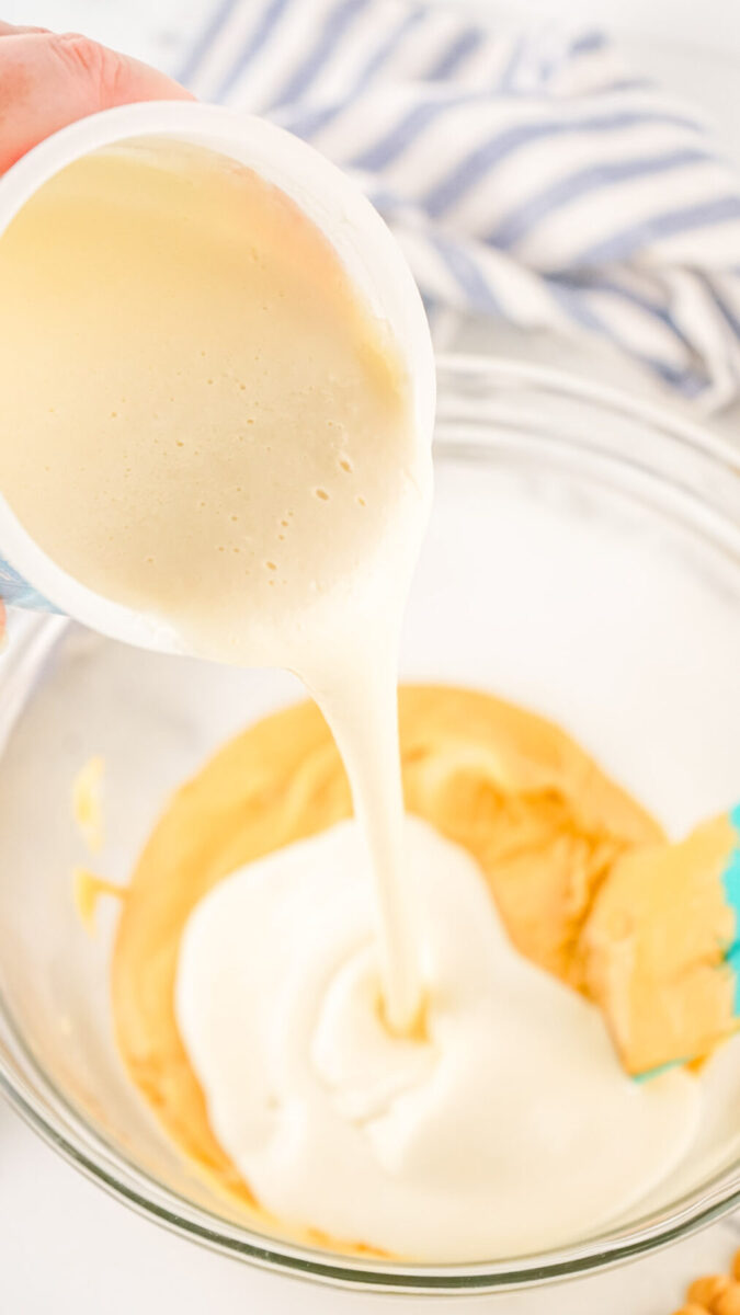 Pouring icing on to a bowl of melted chocolate chips.