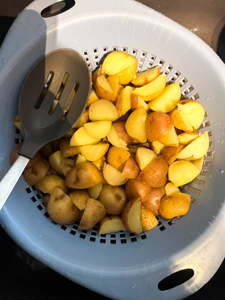Boiled potatoes in a strainer.