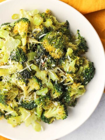 Roasted broccoli on a white plate.