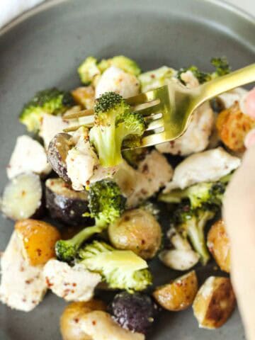 Sheet Pan Chicken Broccoli and Potatoes on a gold fork.