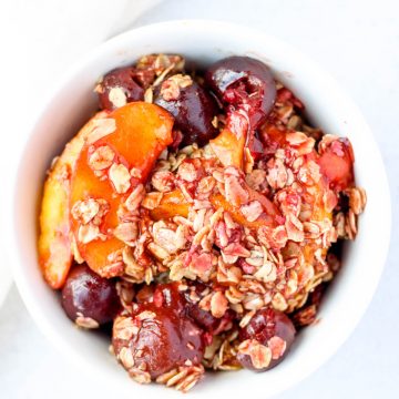 Small bowl of Healthy Cherry and Peach Crisp with Oat Crumble.