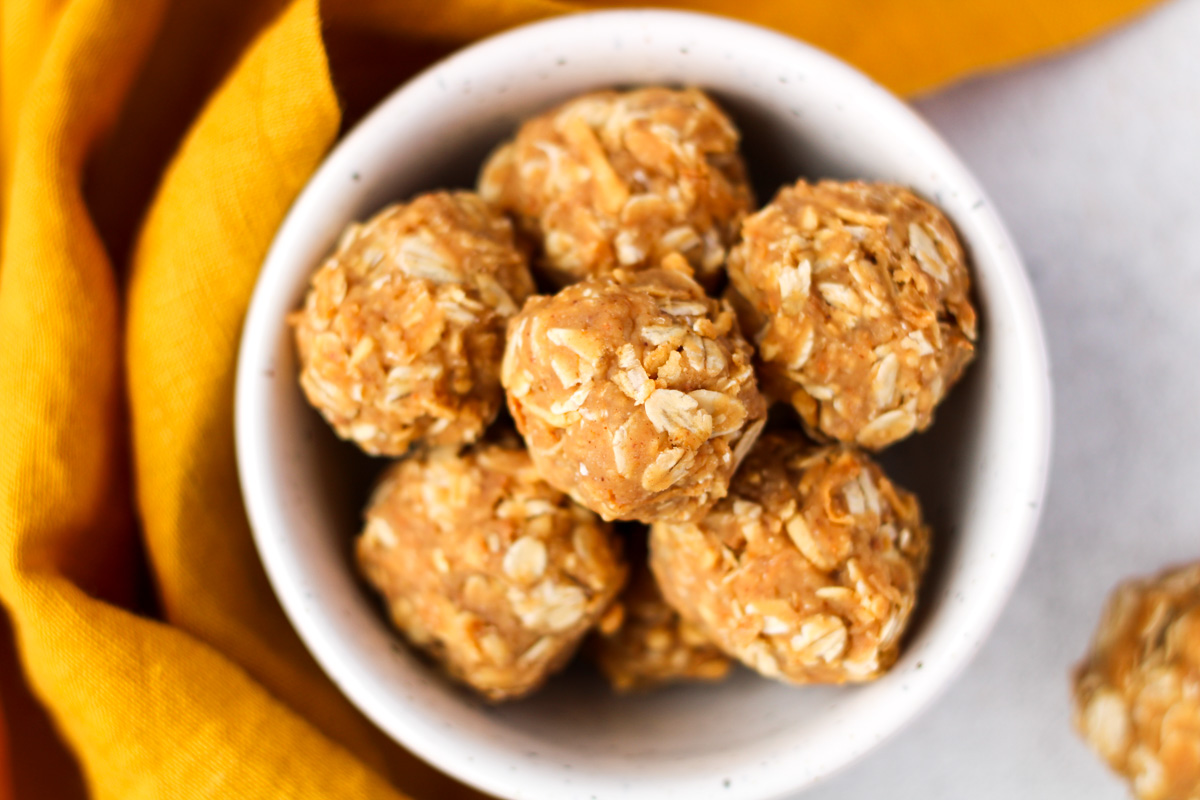 Small white bowl of peanut Butter Coconut Energy Balls.