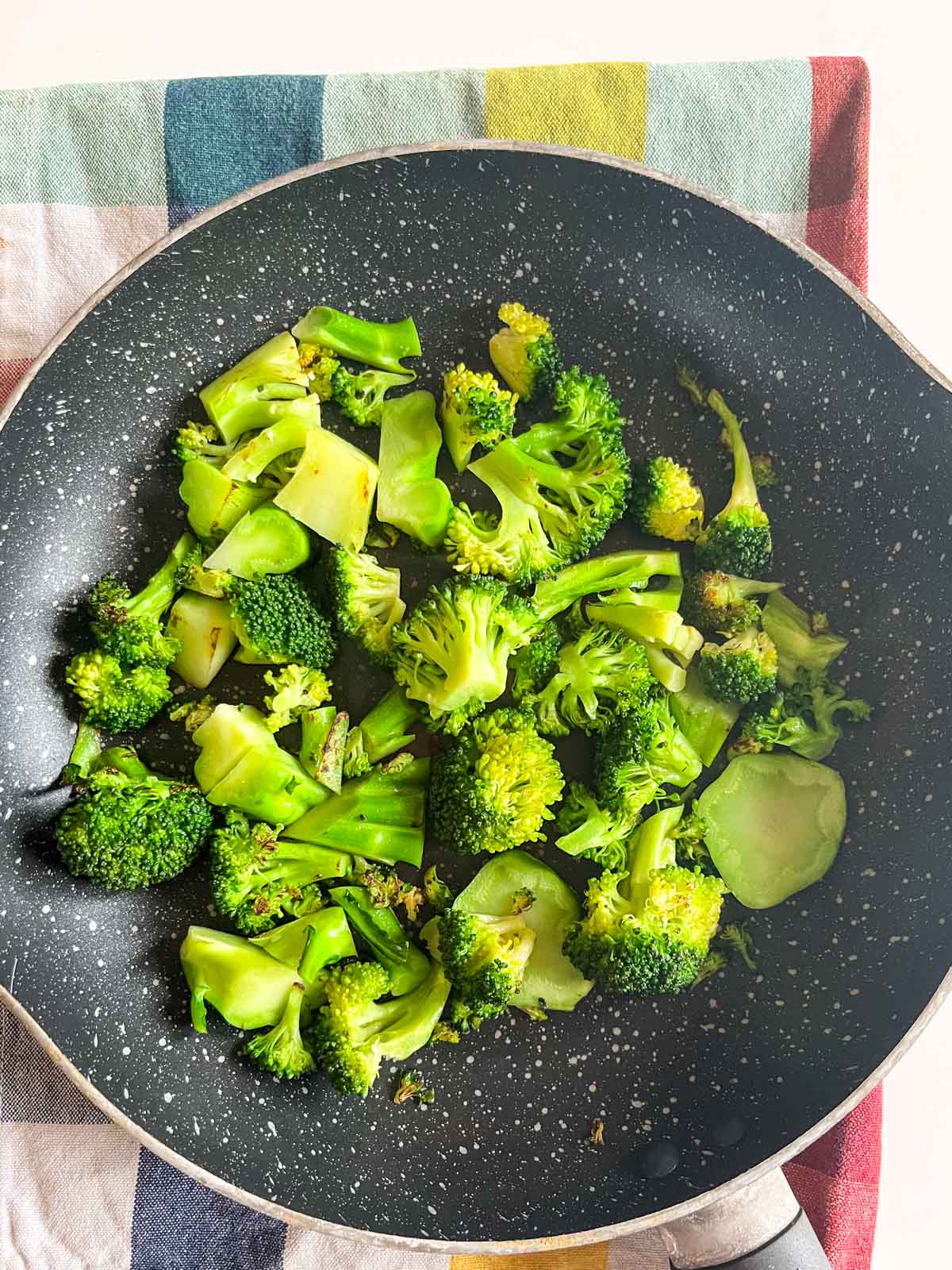 Stir-fried broccoli in a small pan.