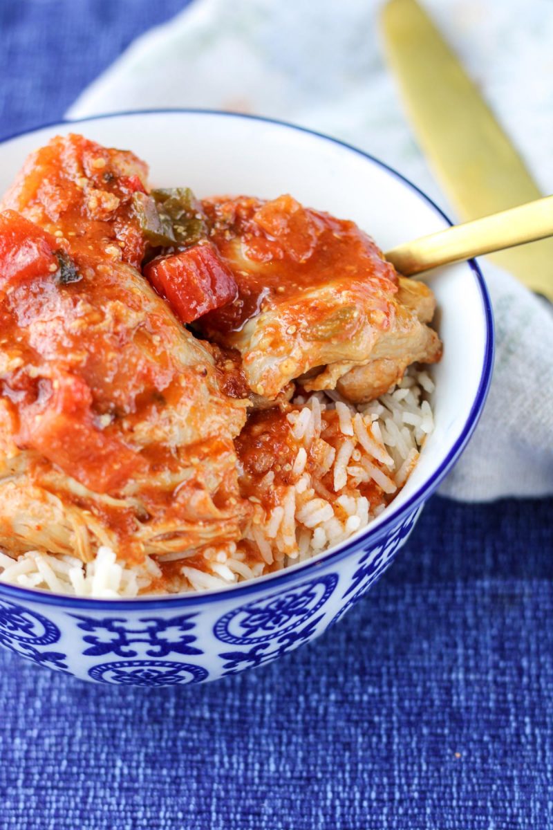 Sweet and Spicy Chicken Thighs with white rice in a blue and white bowl on a blue placemat